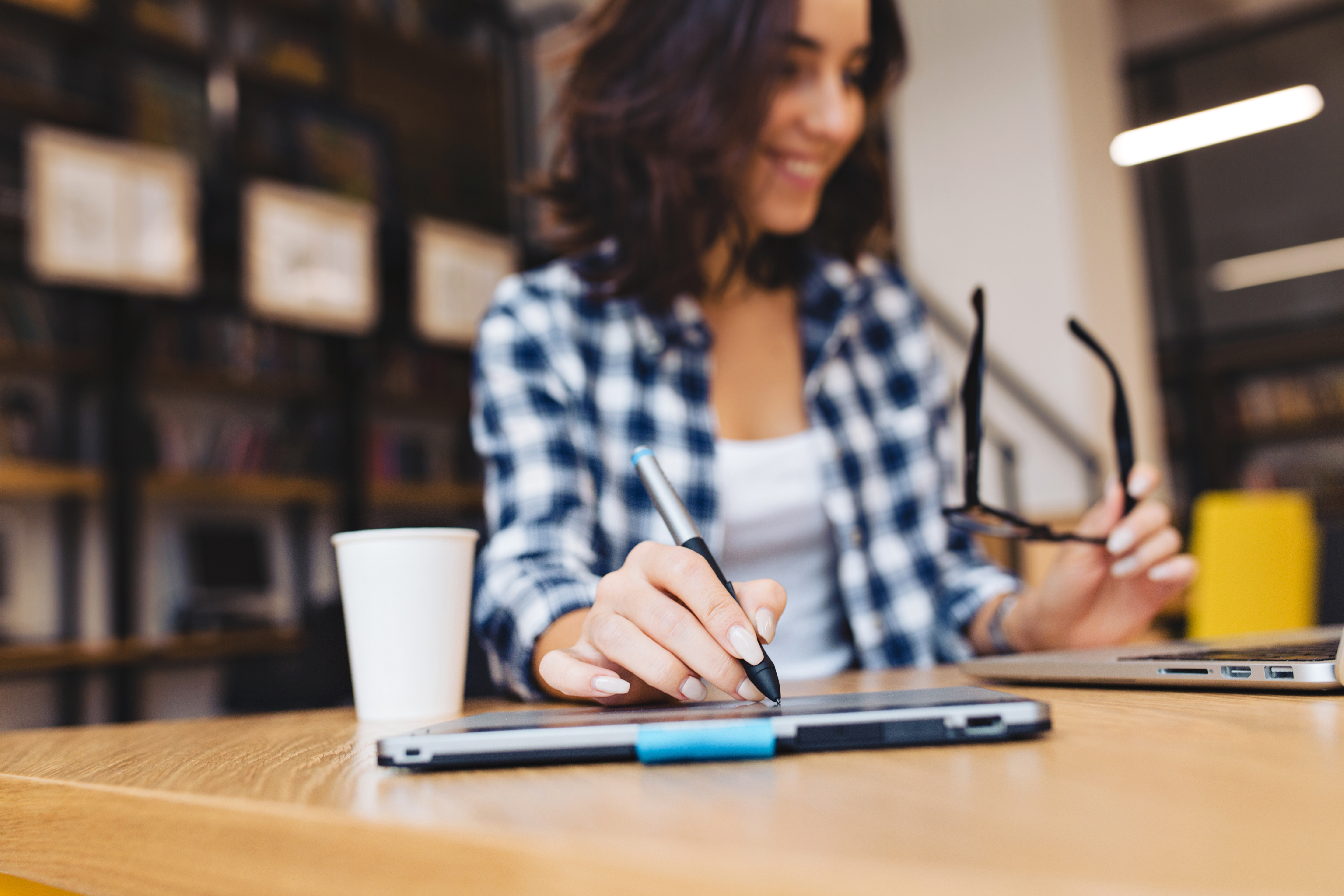 Profissional trabalhando no laptop em ambiente corporativo, representando aprendizado no fluxo de trabalho e estratégias modernas de T&D
